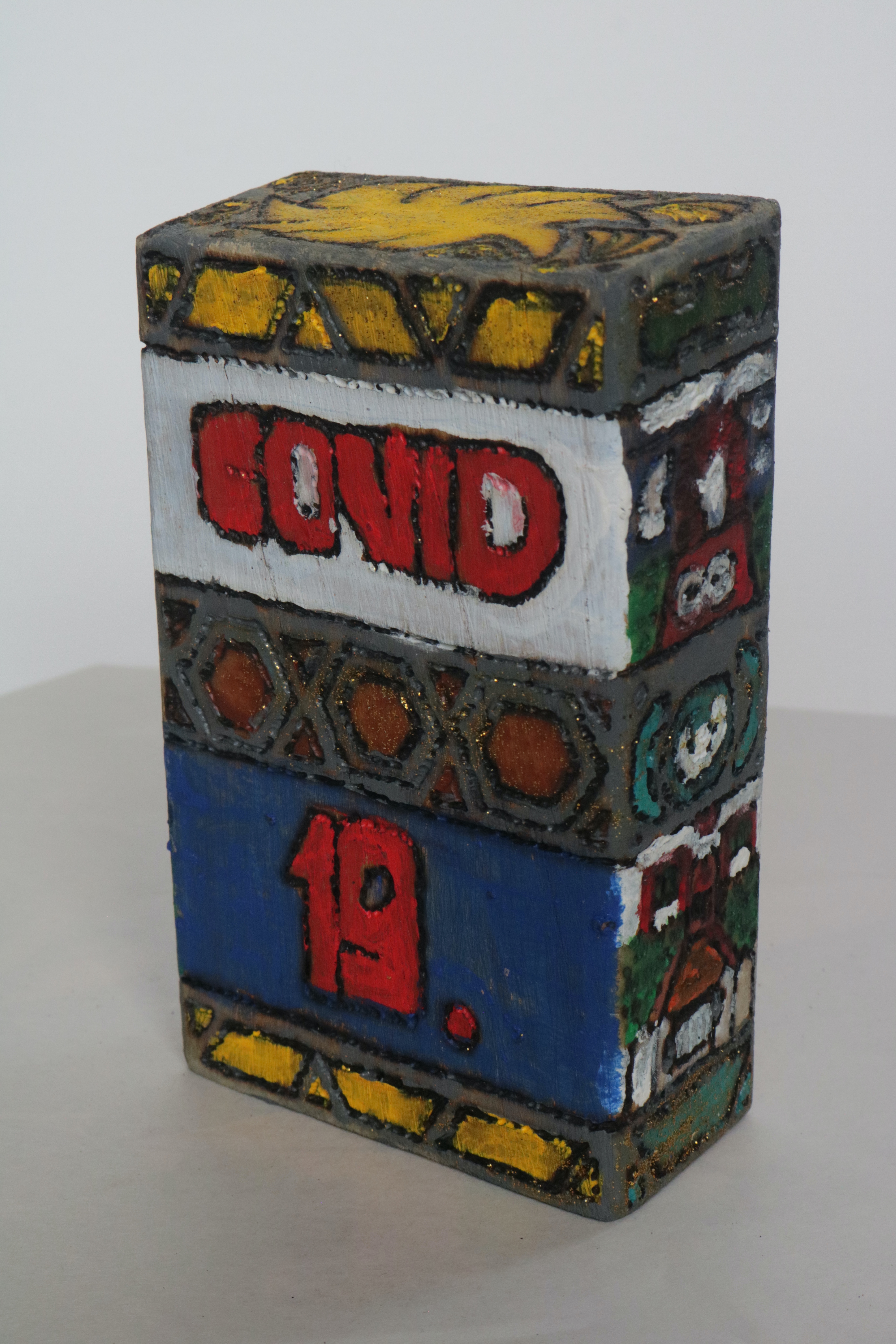 a short squat block. In red the words bold, COVID 19. On the sides are hints of other structures painted.