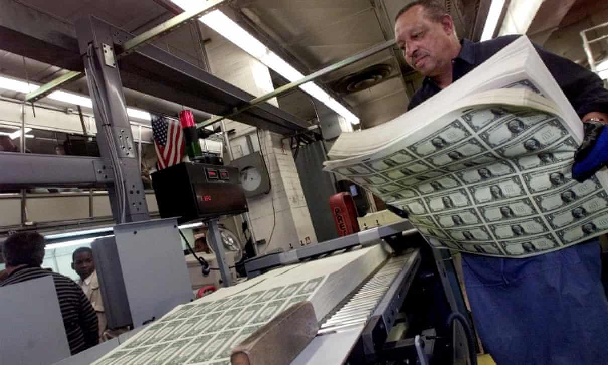a worker at the mint with sheets of uncut money