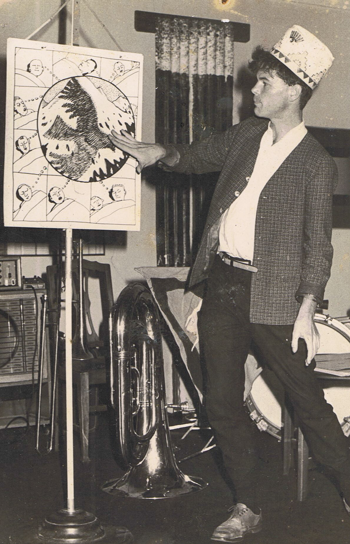 A photo of Gerard telling a story in front an easel with his drawings