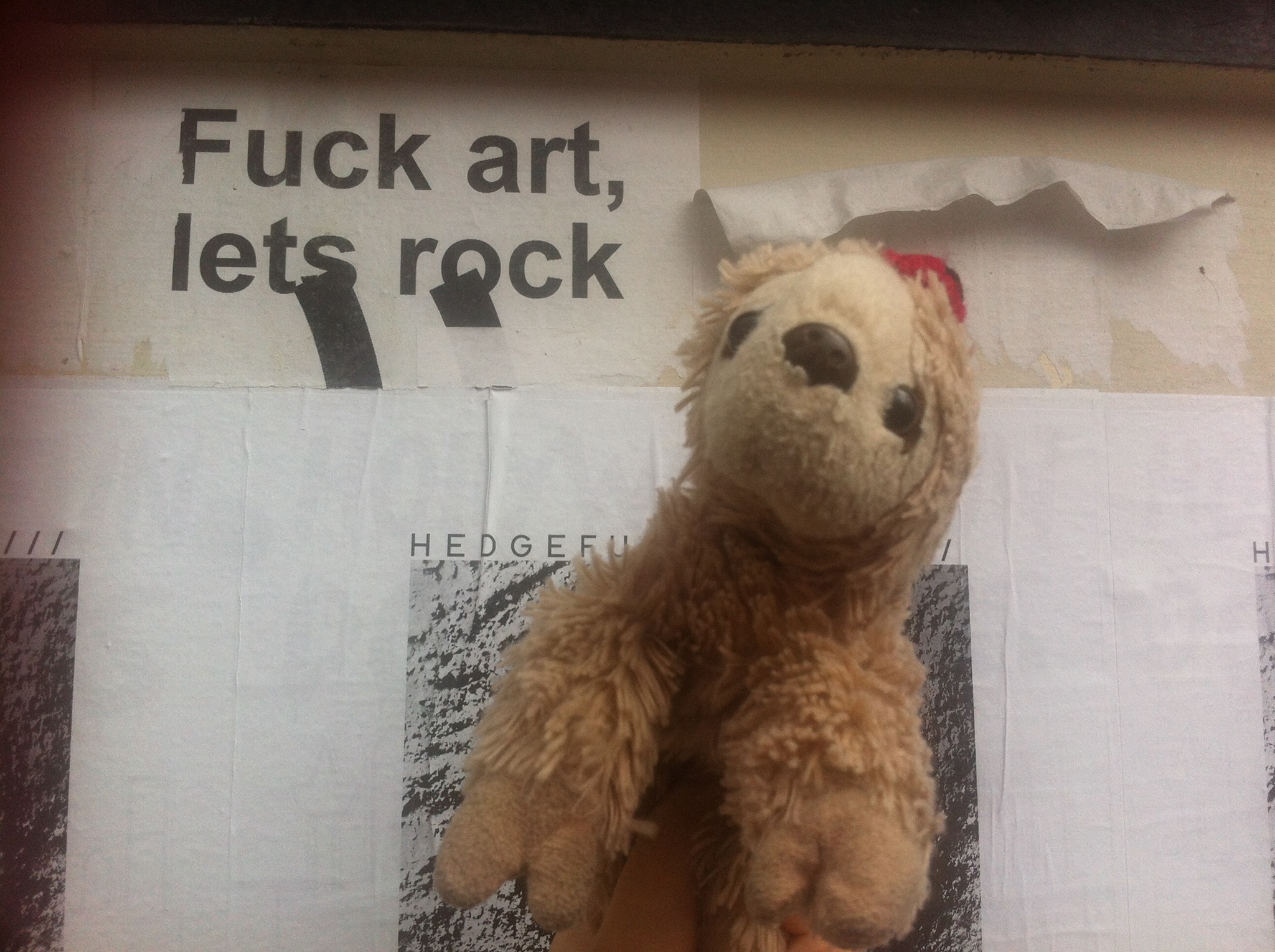 comrade snuggleton beside some graffiti that reads "fuck art, lets rock"