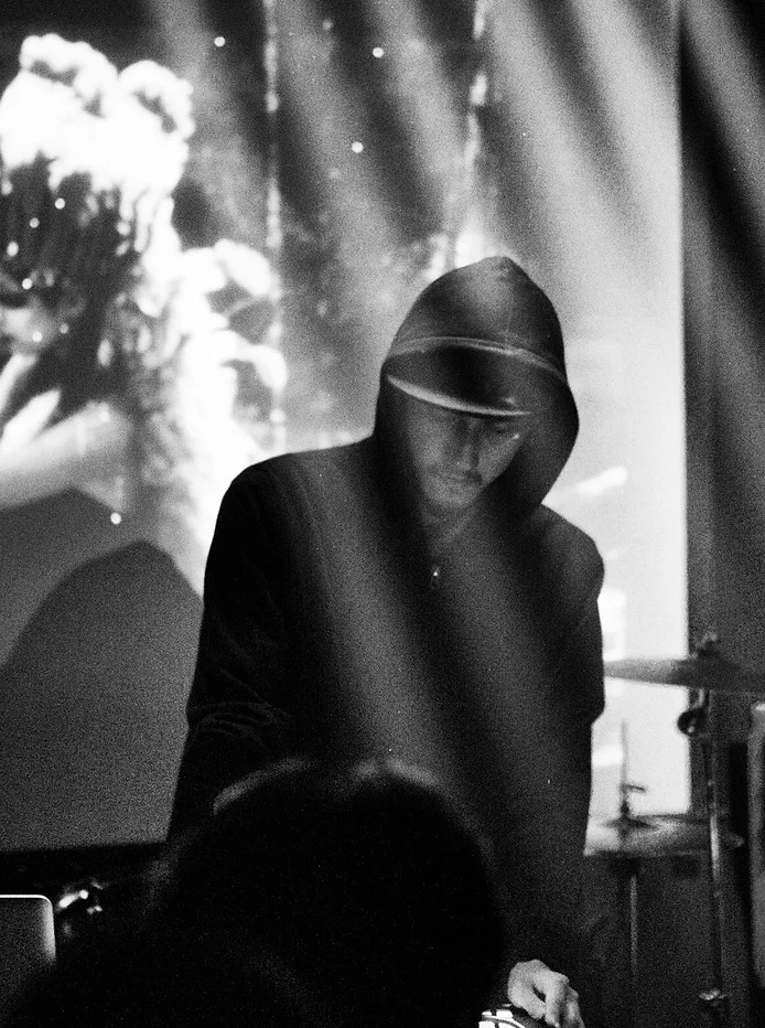 a black and white photo of Immanuel playing electronic music