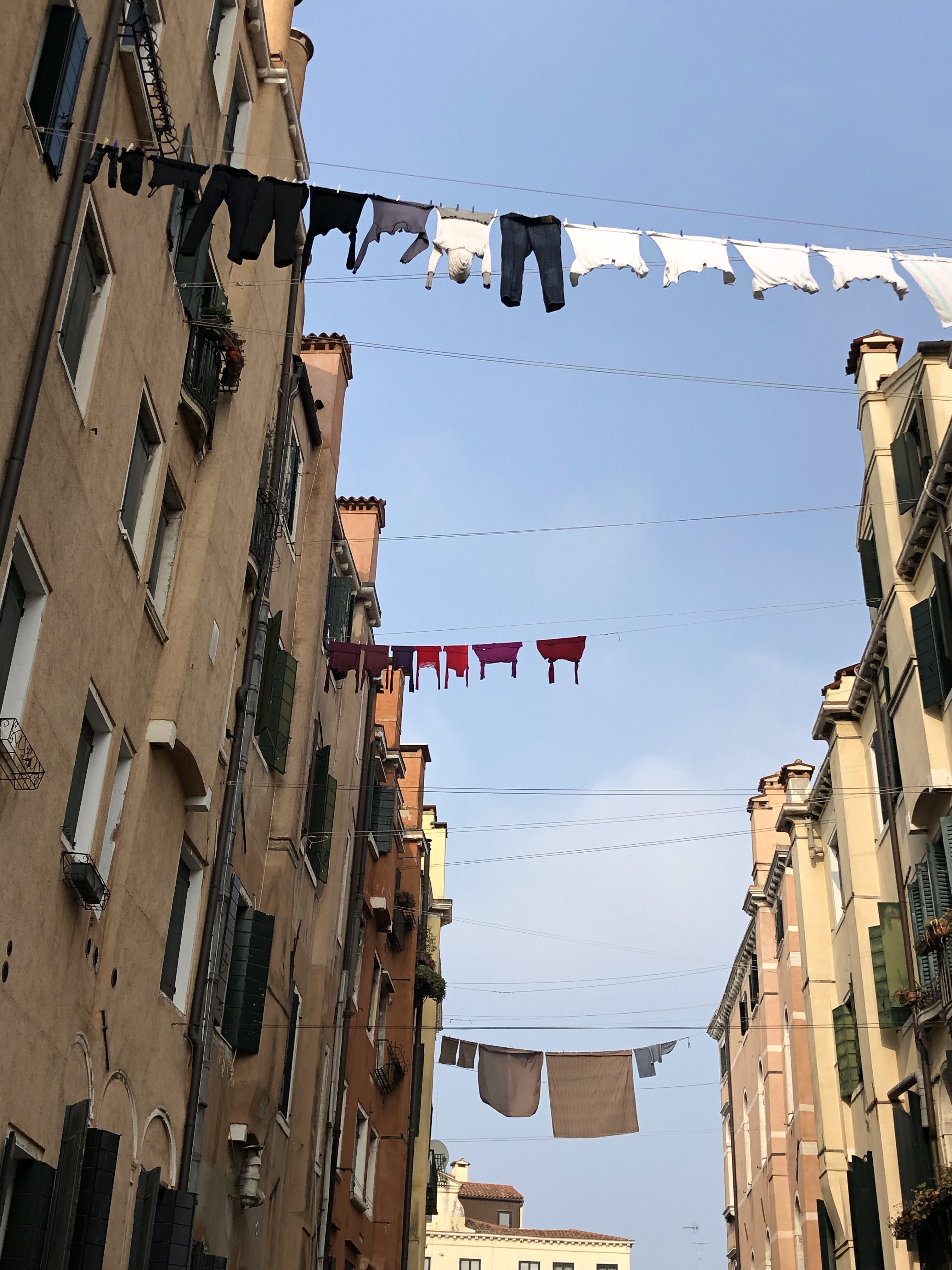 The washing lines span between the buildings, hanging high above the canals of venice