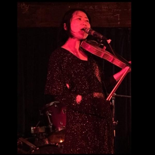Motoko singing into a microphone