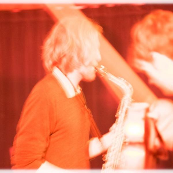 a blurry sepia toned photo of Glen with his saxophone