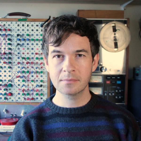 A young Kraus stands in front of his home made modular synthesiser.