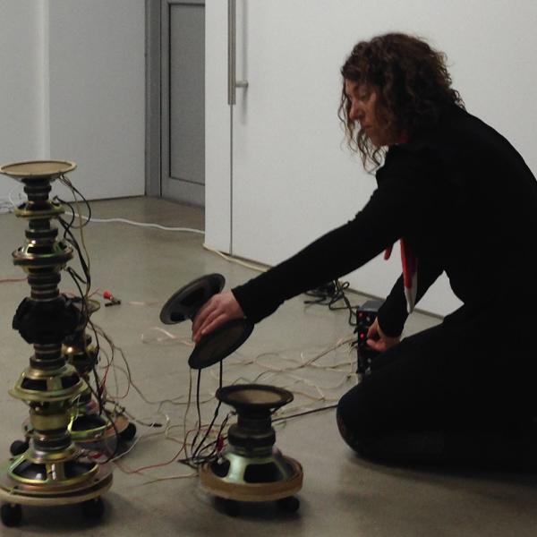 Charlotte stacking up raw exposed speakers cones.