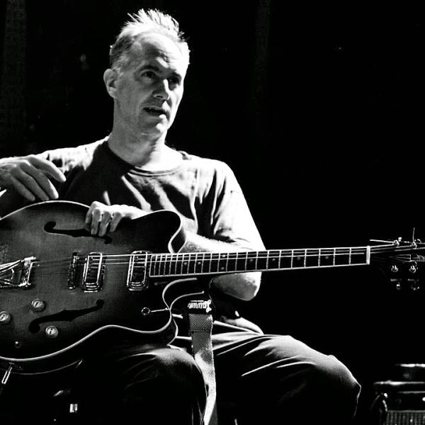 David Watson with a guitar, B&W photo