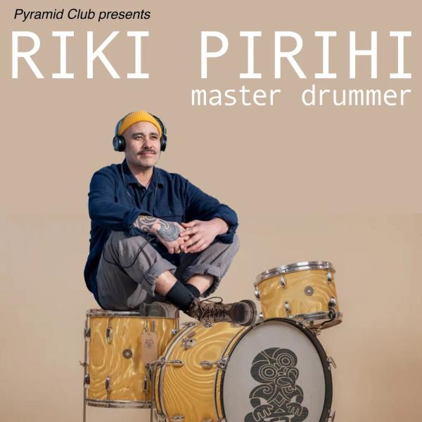 Riki Pirihi sits on a yellow drumkit with a blank background