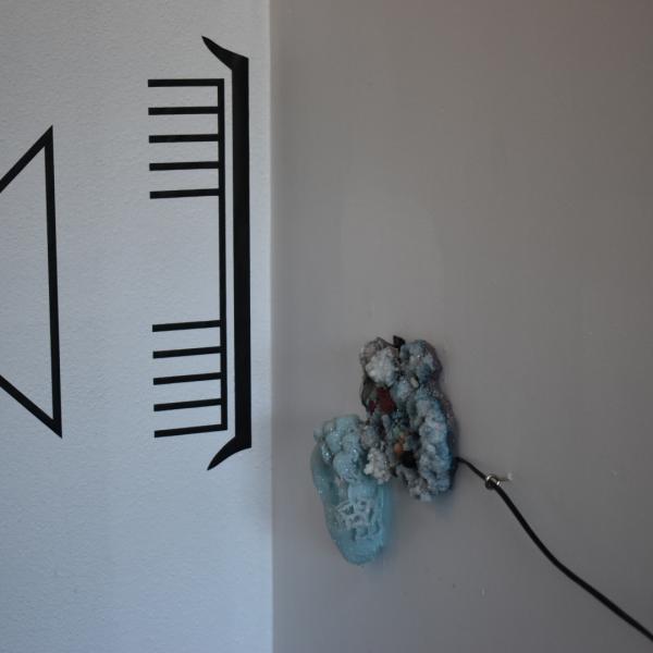 a work from Charlotte Parallel's exhibition. A circuit diagram is enalrged and taped to the wall. It shows a speaker. there are crystals wired for sound