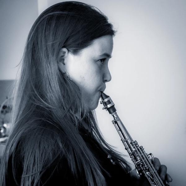 Jasmine in profile playiing a soprano saxophone