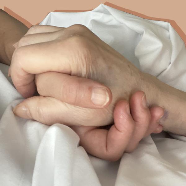 two hands are held. The hand underneath is that of the daughter and composer Chrissie. The hand on top is that of her dying mother. the hands are grasped in love. There is a crumpled sheet that the hand are on, it seems the mother is in bed.