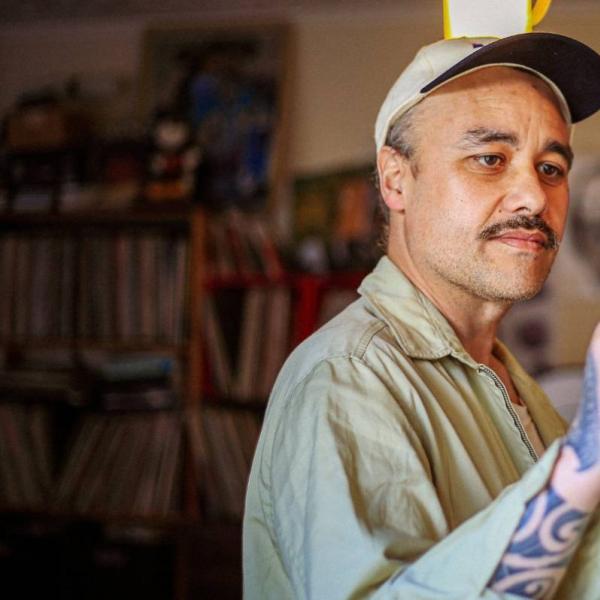 Riki using an albatross bone as a baton to conduct an unseen orchestra.