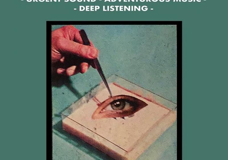 A hand with tweezers plucking an eye in a petri dish