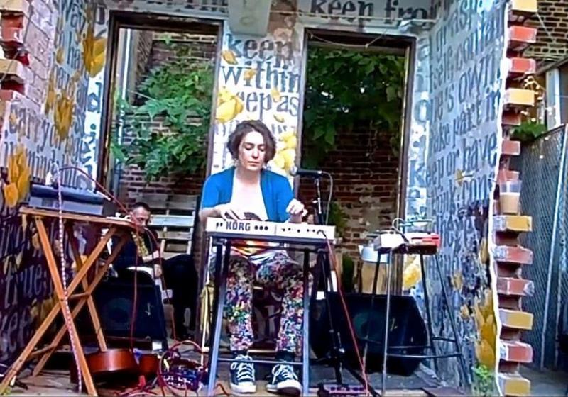 Rosie Langabeer performing outdoors in half a brick shed