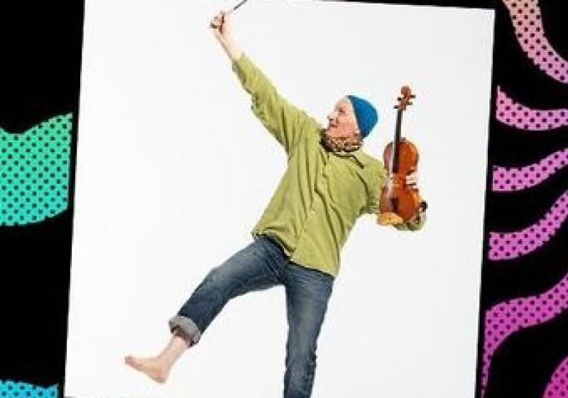 Chris looking wacky. Holding a violin and raising a hand to the air.