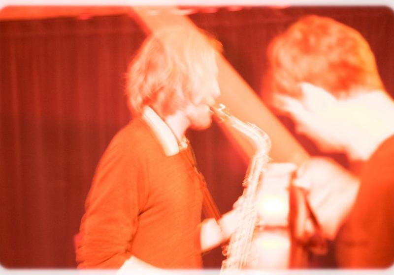 a blurry sepia toned photo of Glen with his saxophone