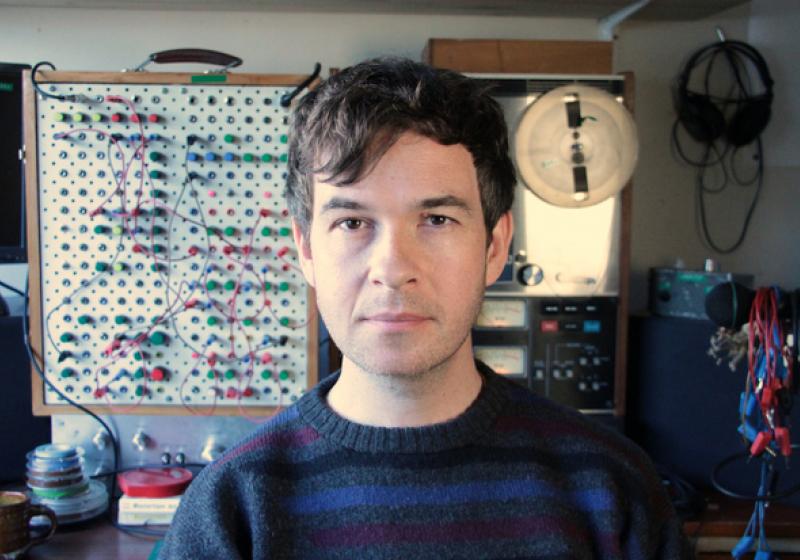 A young Kraus stands in front of his home made modular synthesiser.