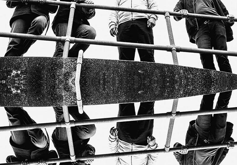 A photo of the band standing by a long metal hand rail