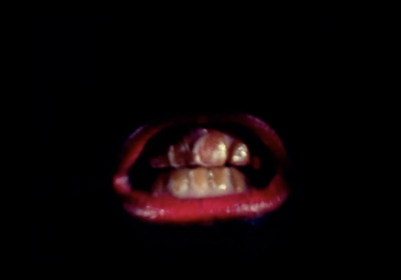 A pair of snarling, lipstick covered lips are in the centre of a black background