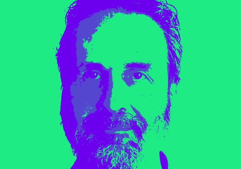 A duo-tone print of Simon O'Rorke looking directly into the camera. The background is bright green and the shadows that make up the outline of his face are purple-blue