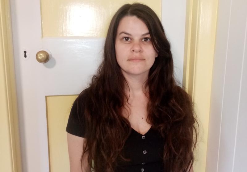 Lucy is dressed in black and standing in front of a yellow door. The door makes me think of an older house, a much loved house.