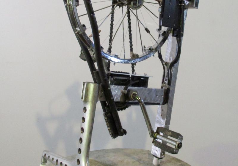 Neil Feather's 'Melocycle' invented instrument from 2016. The instrument combines a bicycle wheel with pedals and some kind of mechanism that appears to perhaps strum the spokes of the wheel. 