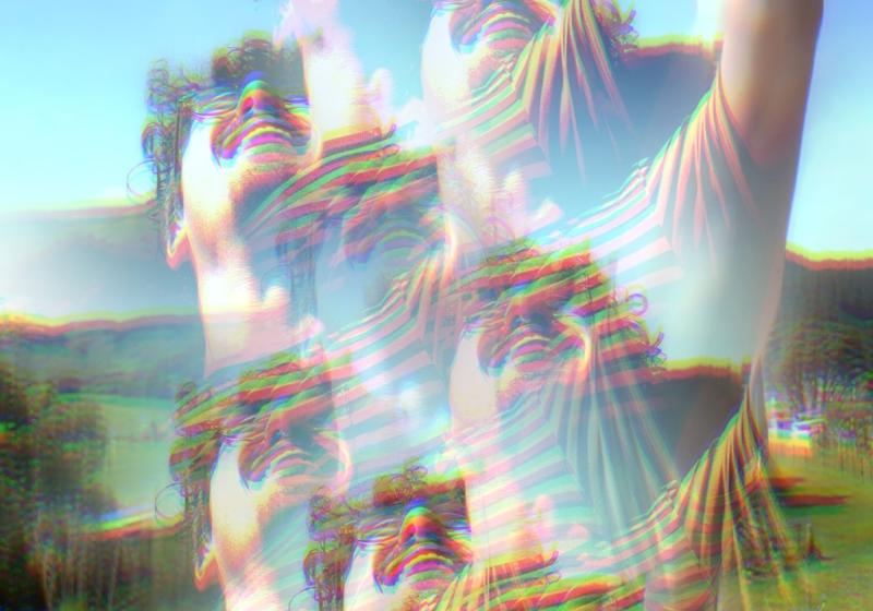 A kaleidoscopic hazy view of George Johnston frolicking in a field, with bright saturated colours