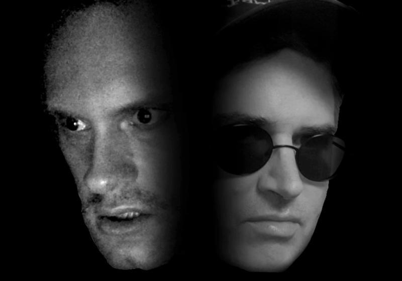 two faces appear, close up and side by side out of a black background. The face images are in black and white. The left one has a very intense stare and the second is smug with dark sunglasses.