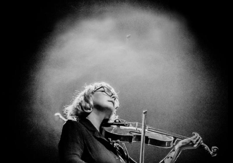 black and white vignetted photo of Motte playing violin
