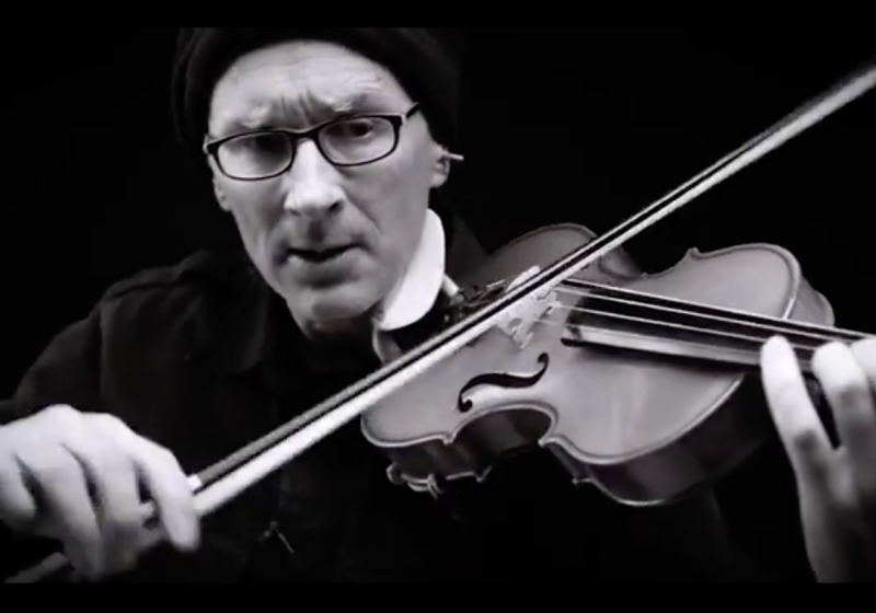 A black and white photo close-up of Chris Prosser playing the violin