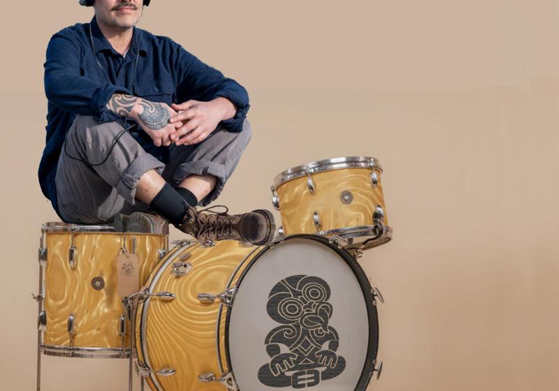 Riki sits on drum kit