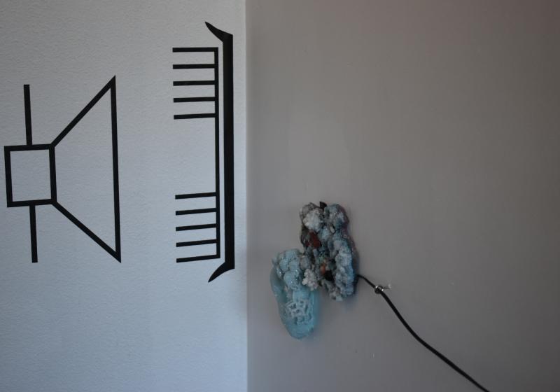a work from Charlotte Parallel's exhibition. A circuit diagram is enalrged and taped to the wall. It shows a speaker. there are crystals wired for sound