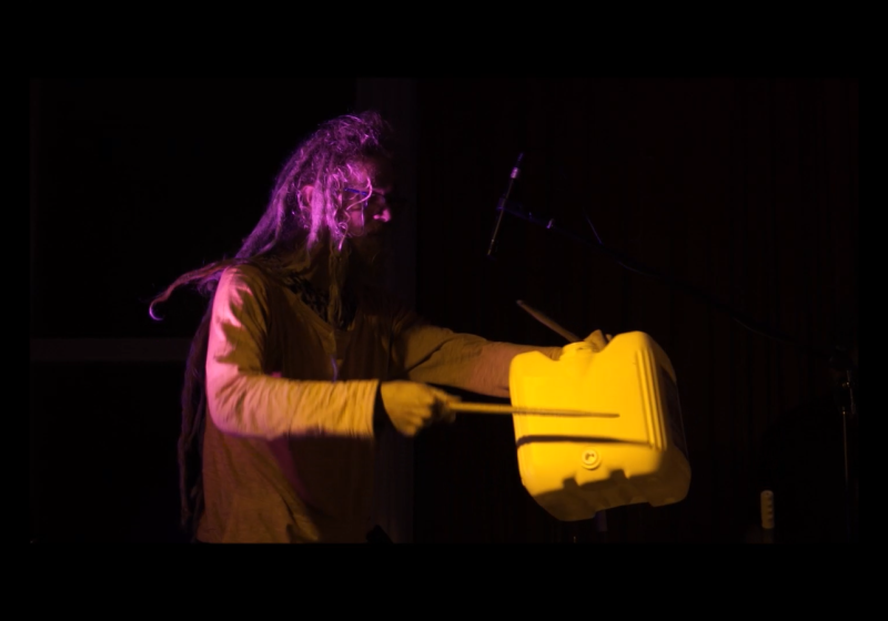 Liam playing a large cube shaped plastic container for liquids