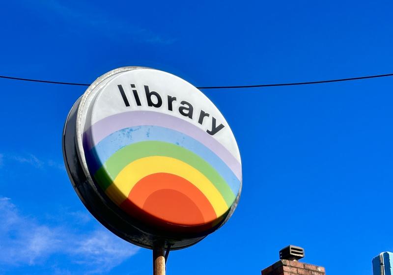 the Miramar Library sign. A round sign that simply says library, the bottom half of the circle is a solid rainbow.