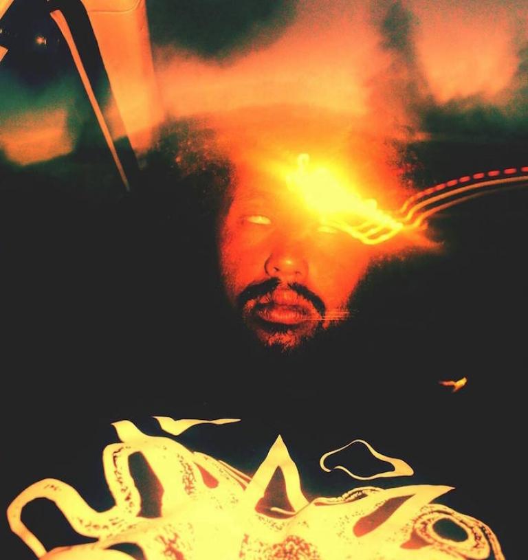 a blurred and blown out photo of ENT, Nathan Taare. The colours a warm and like fire.