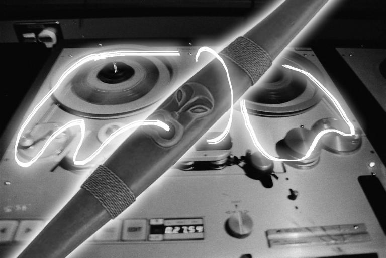 a pūtōrino is aglow, white neon magnetic tape cascading around it and fusing it to a reel to reel