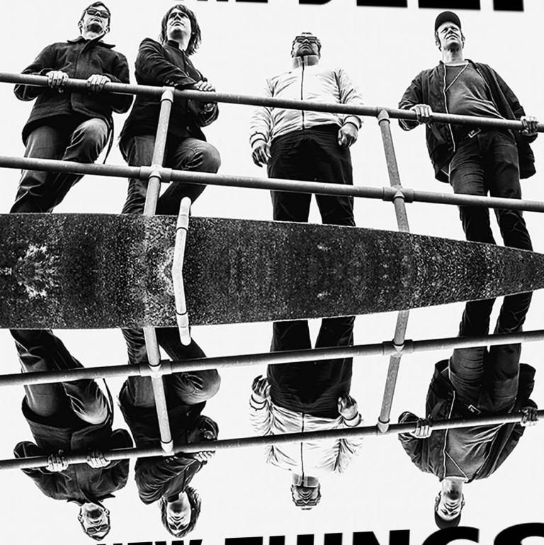 A photo of the band standing by a long metal hand rail