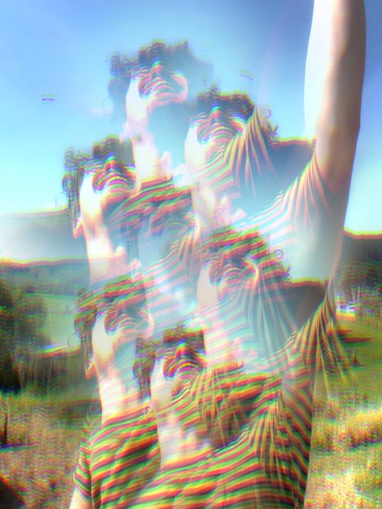 A kaleidoscopic hazy view of George Johnston frolicking in a field, with bright saturated colours