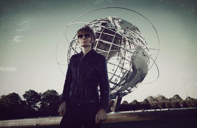 JG Thirwell standing in front of the spherical stainless steel 'Unisphere' representation of the Earth in Flushing Meadows–Corona Park in Queens, New York City.