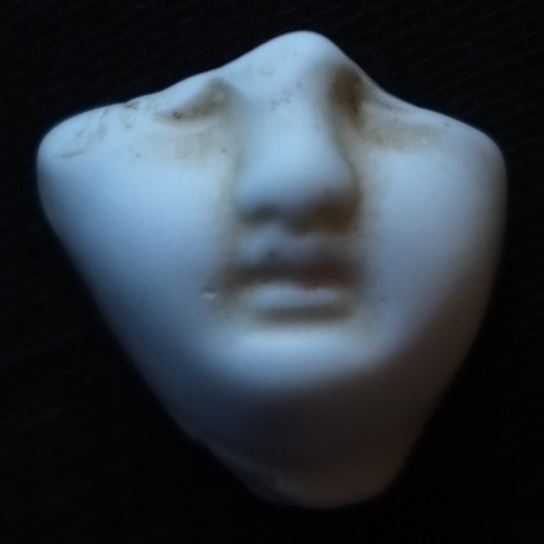A broken shard of the bottom half of a porcelain doll's face
