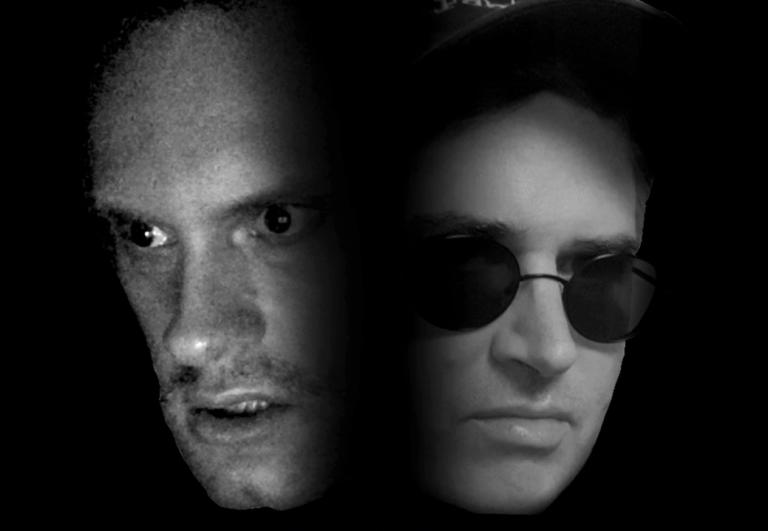 two faces appear, close up and side by side out of a black background. The face images are in black and white. The left one has a very intense stare and the second is smug with dark sunglasses.
