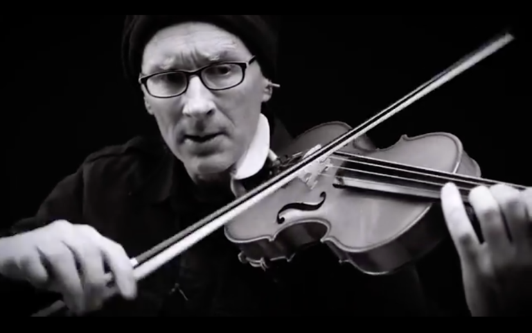 A black and white photo close-up of Chris Prosser playing the violin