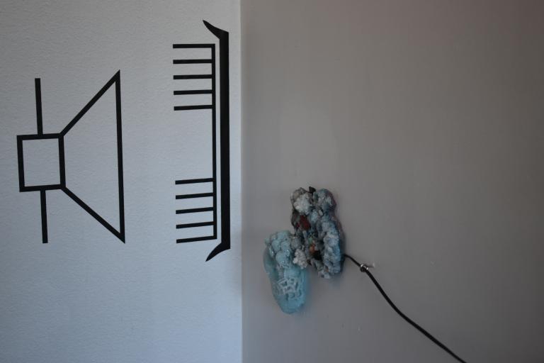 a work from Charlotte Parallel's exhibition. A circuit diagram is enalrged and taped to the wall. It shows a speaker. there are crystals wired for sound