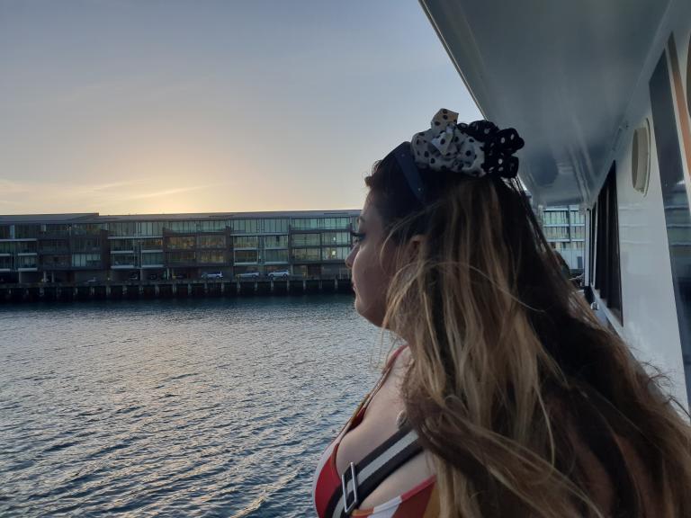 a profile shot of Heleyni looking out over the expensive apartments on the Wellington waterfront