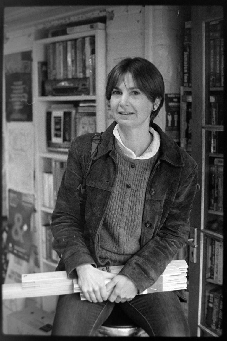 a person sitting on a stool and clutching small lengths of timber